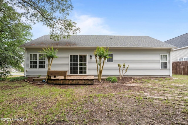 back of property featuring a deck and fence