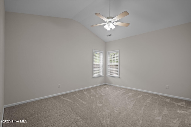 spare room featuring carpet, ceiling fan, vaulted ceiling, and baseboards