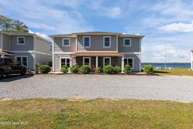 view of front of house featuring a water view and a front lawn