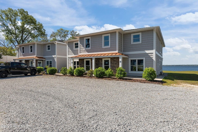 view of front of house with a water view, metal roof, and a standing seam roof