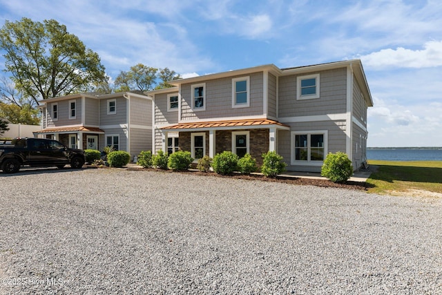 view of front of house featuring a water view, metal roof, and a standing seam roof
