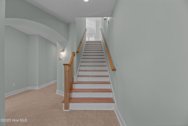 staircase featuring baseboards and tile patterned floors