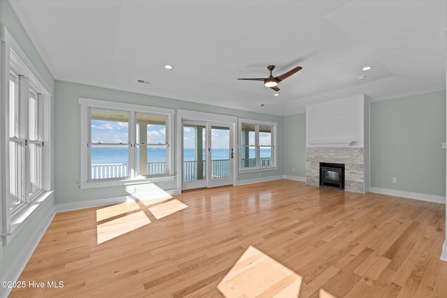 unfurnished living room featuring visible vents, light wood-style floors, ceiling fan, and baseboards