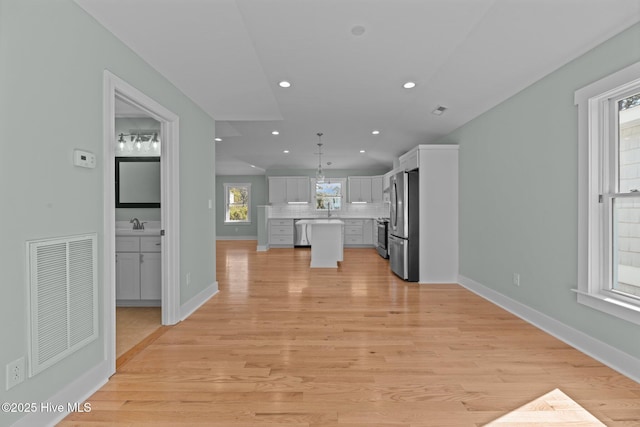 interior space with backsplash, visible vents, appliances with stainless steel finishes, light countertops, and white cabinets