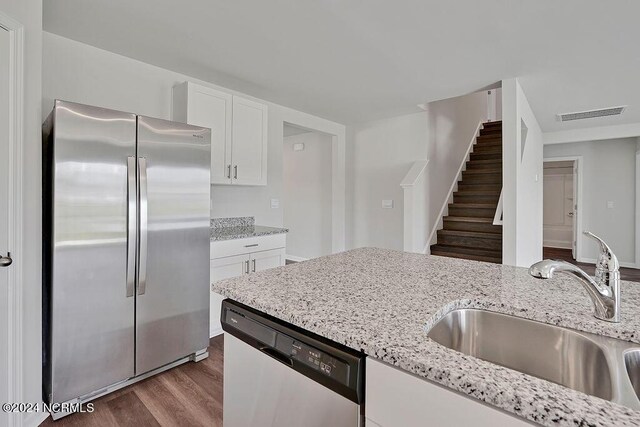 238 Kite Cir NE Lot 666, Bolivia, NC 28422 - kitchen with light stone counters, stainless steel appliances, dark wood-style flooring, a sink, and white cabinetry