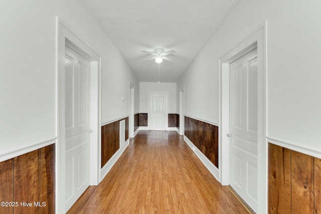 310 Chicopee Rd, Benson, NC 27504 - hallway with a wainscoted wall, light wood-style floors, and a textured ceiling
