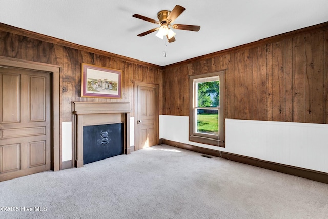 310 Chicopee Rd, Benson, NC 27504 - unfurnished living room featuring wooden walls, carpet flooring, ornamental molding, and a ceiling fan
