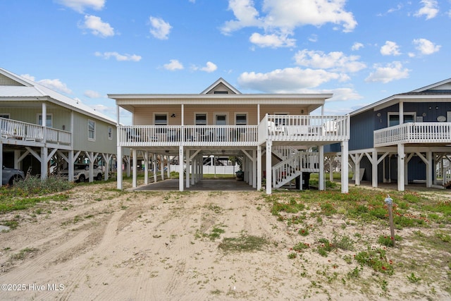 461 E Third St, Ocean Isle Beach, NC 28469 - view of front facade featuring a carport, dirt driveway, a porch, and stairway