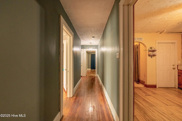 503 Spring St, Hamlet, NC 28345 - corridor with light wood finished floors, a textured ceiling, and baseboards