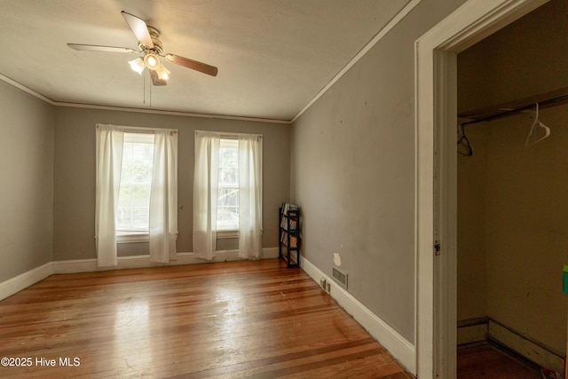 503 Spring St, Hamlet, NC 28345 - unfurnished bedroom featuring crown molding, light wood finished floors, a textured ceiling, baseboards, and ceiling fan