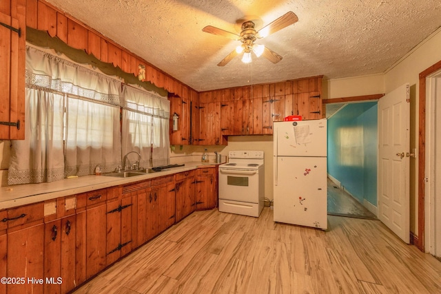 503 Spring St, Hamlet, NC 28345 - kitchen featuring white appliances, a textured ceiling, brown cabinets, light wood finished floors, and light countertops