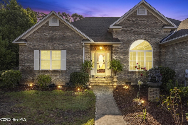 view of front of property with crawl space and brick siding