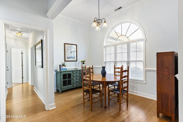 dining room featuring visible vents, crown molding, plenty of natural light, and light wood-type flooring