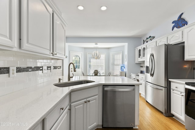 kitchen featuring backsplash, stainless steel appliances, white cabinetry, and a sink