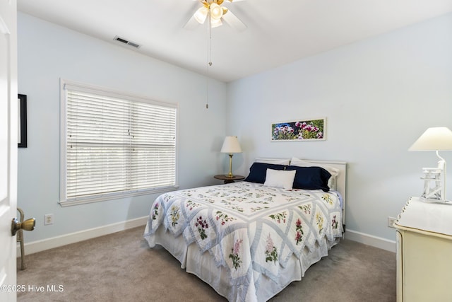carpeted bedroom with visible vents, baseboards, and ceiling fan