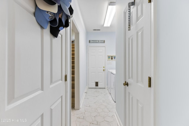 hall with baseboards, marble finish floor, visible vents, and washing machine and clothes dryer