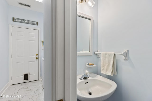 bathroom with a sink, marble finish floor, and visible vents
