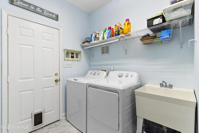 laundry area featuring laundry area, visible vents, marble finish floor, washing machine and dryer, and a sink