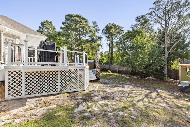 view of yard with a fenced backyard, a shed, an outbuilding, and a deck