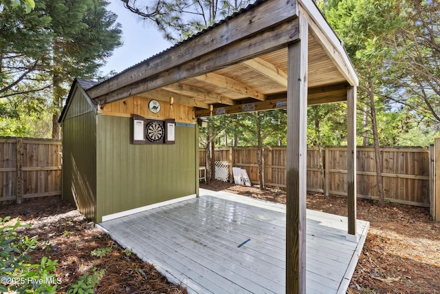 wooden deck featuring a fenced backyard and an outbuilding