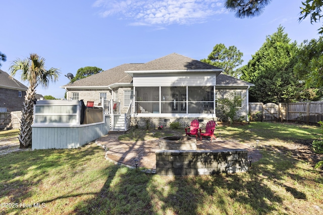 rear view of property with a fire pit, a fenced backyard, roof with shingles, a sunroom, and a gate