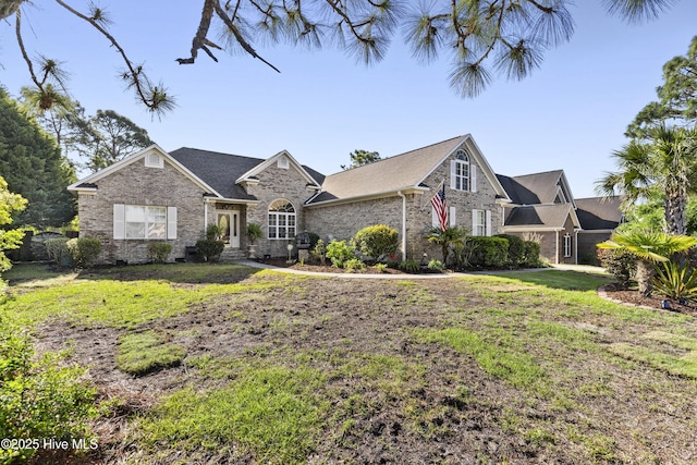 view of front of home featuring a front lawn and brick siding