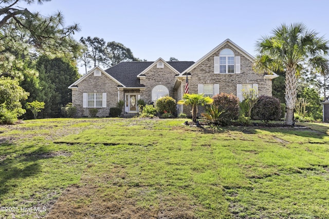 traditional-style home with brick siding and a front lawn