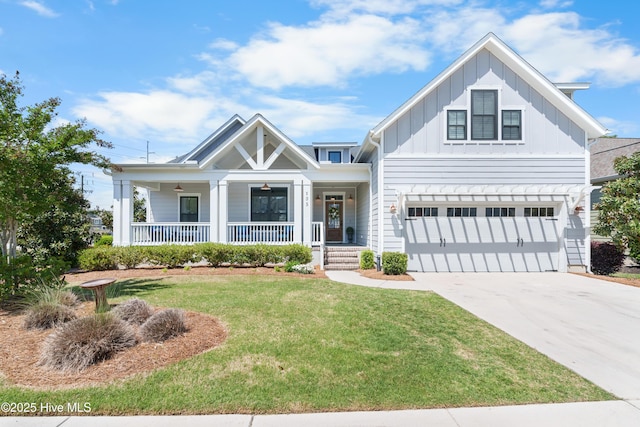 view of front facade with driveway, board and batten siding, a front yard, a porch, and a garage