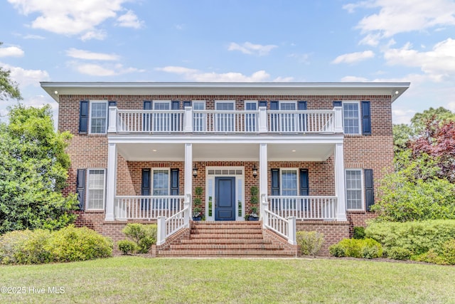 view of front of home with a porch, a balcony, and brick siding