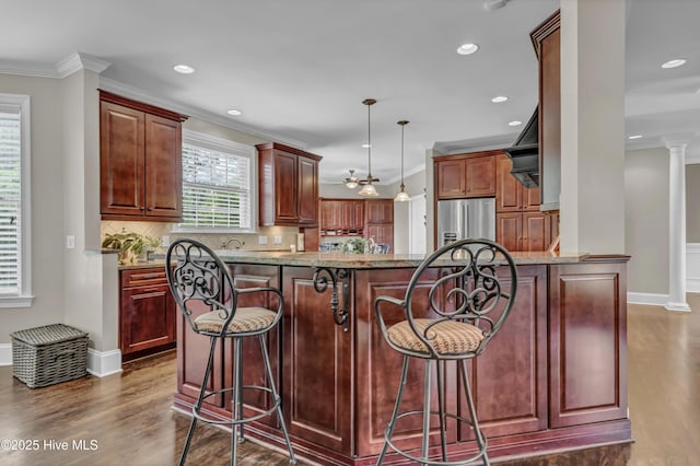 kitchen featuring ornamental molding, decorative backsplash, a breakfast bar, dark wood-style floors, and stainless steel refrigerator with ice dispenser