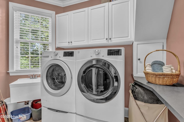clothes washing area with a sink, ornamental molding, washing machine and dryer, and cabinet space