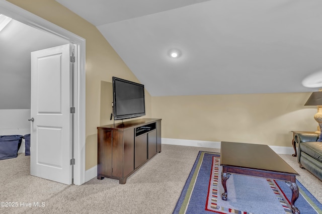 living room with carpet floors, baseboards, and lofted ceiling