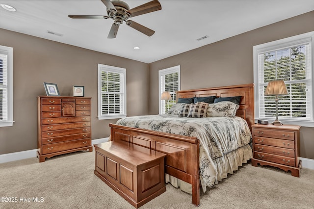 bedroom with multiple windows, light carpet, and visible vents