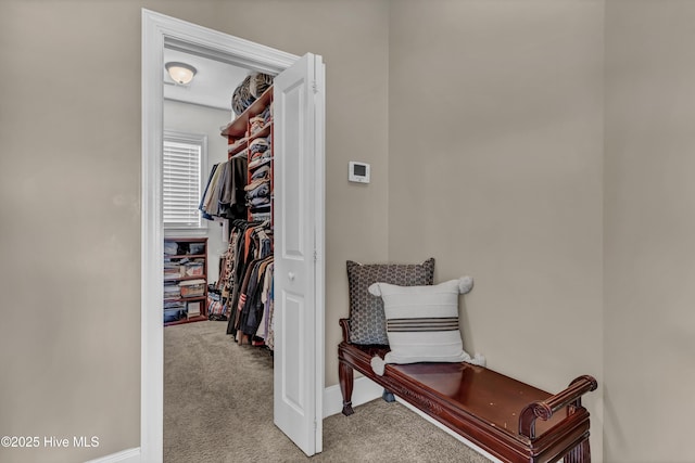 corridor with baseboards and light carpet