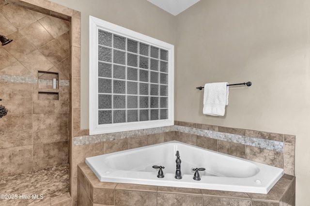 full bathroom with a garden tub and tiled shower