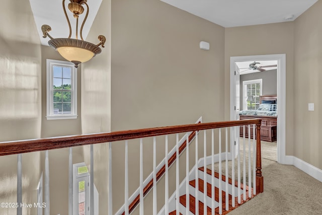 corridor with baseboards and carpet