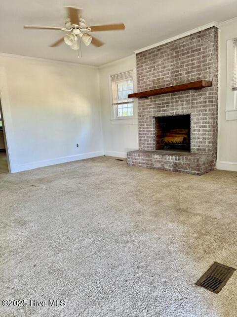 unfurnished living room with ceiling fan, ornamental molding, carpet, and visible vents