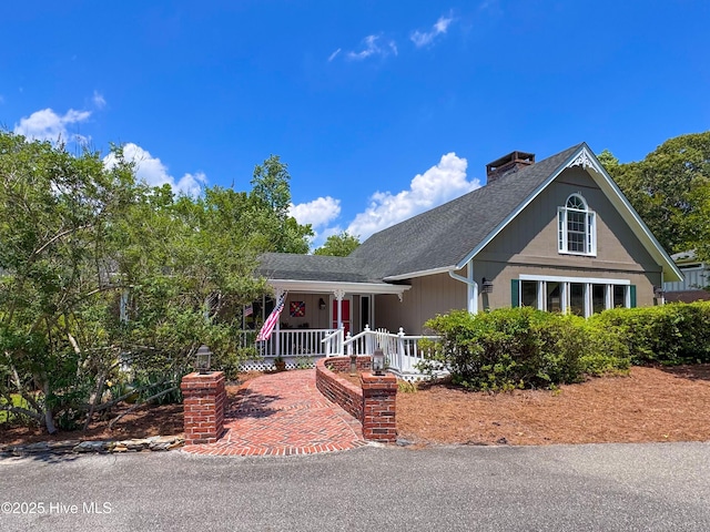 522 Hughes Rd, Hampstead, NC 28443 - view of front of home with a porch, a chimney, and roof with shingles
