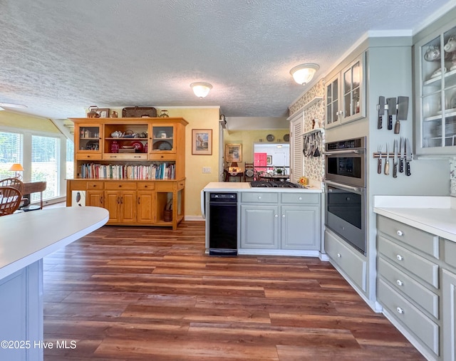 522 Hughes Rd, Hampstead, NC 28443 - kitchen with a textured ceiling, dark wood-style floors, a peninsula, glass insert cabinets, and light countertops
