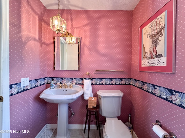 522 Hughes Rd, Hampstead, NC 28443 - bathroom with tile patterned floors, a chandelier, and toilet
