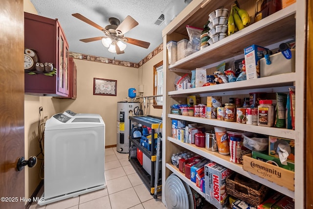 clothes washing area with light tile patterned floors, a textured ceiling, ceiling fan, water heater, and separate washer and dryer