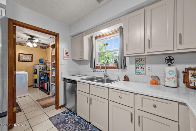 kitchen featuring a sink, light tile patterned floors, light countertops, a textured ceiling, and dishwasher