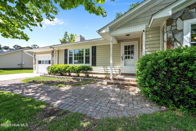 view of front of home featuring a chimney, concrete driveway, and an attached garage