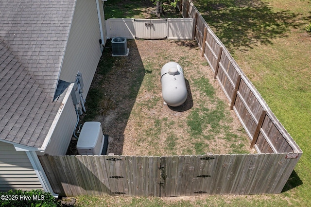 view of yard featuring a gate, a fenced backyard, and central air condition unit