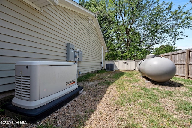 view of yard with central air condition unit and fence