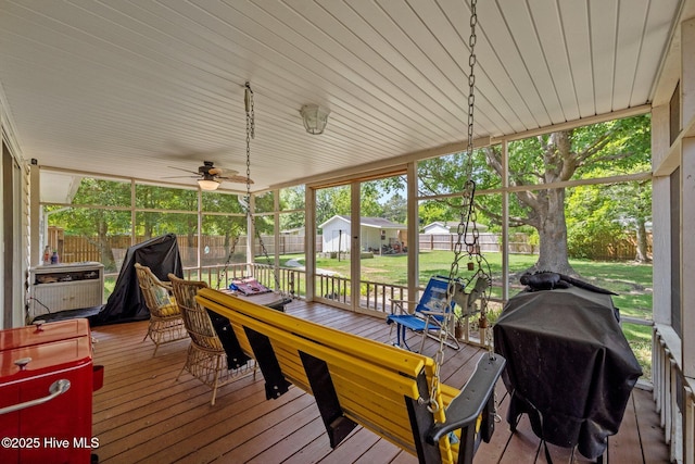 sunroom with a healthy amount of sunlight, a ceiling fan, and outdoor dining area