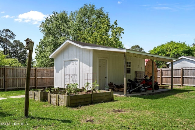 view of outbuilding with a vegetable garden and a fenced backyard