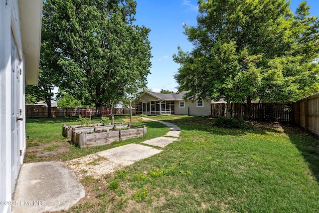 view of yard with a vegetable garden and a fenced backyard