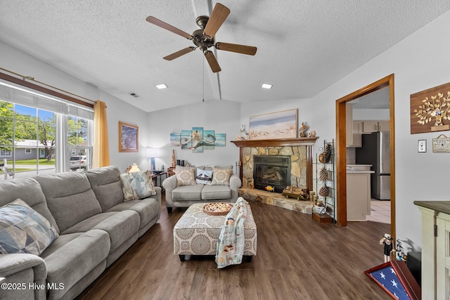 living room featuring wood finished floors, ceiling fan, a textured ceiling, and a fireplace