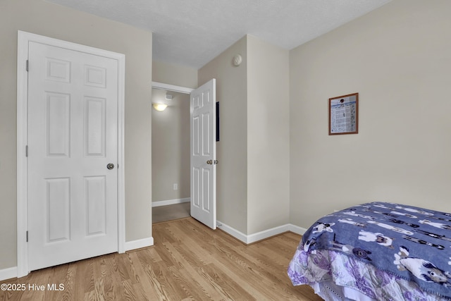 bedroom featuring baseboards and wood finished floors